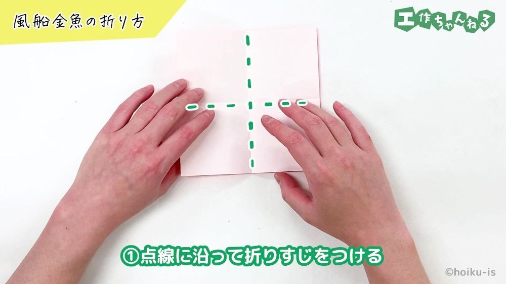 折り紙に折りすじの点線が示されている手元