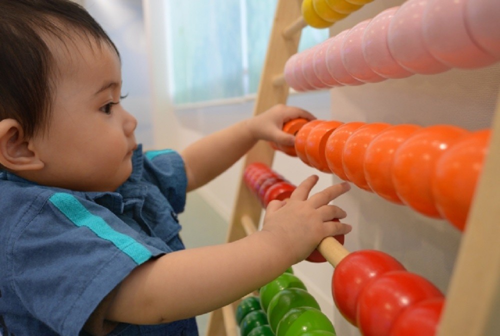 木のおもちゃで遊ぶ幼児