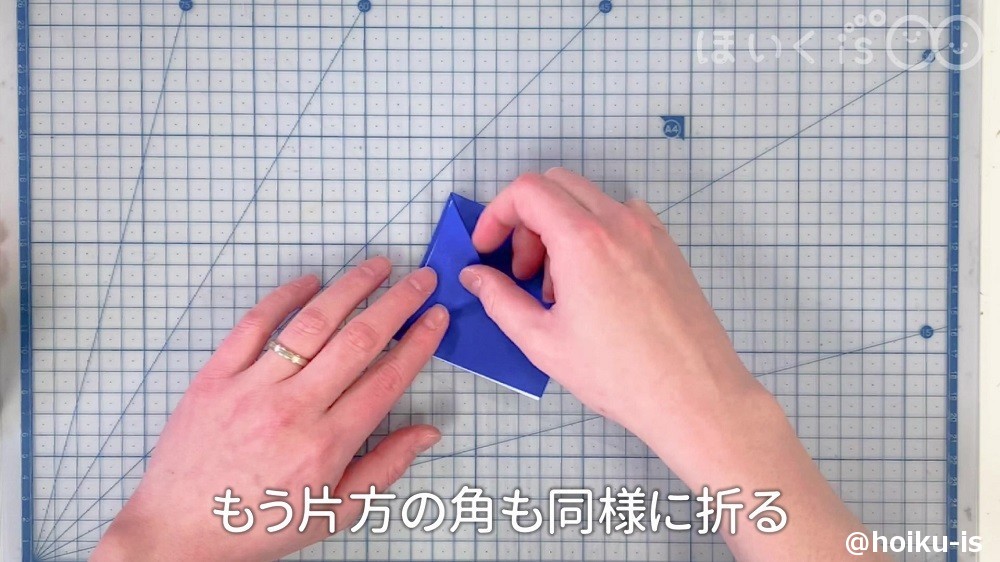 もう片方の角も同様に折っているところ