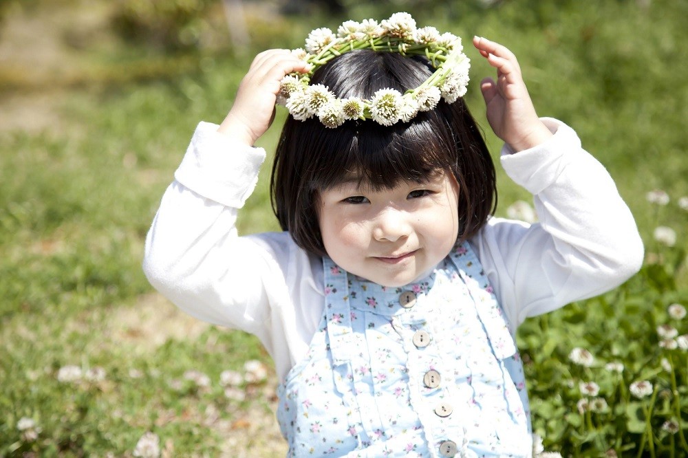 シロツメクサの冠を乗せている子ども