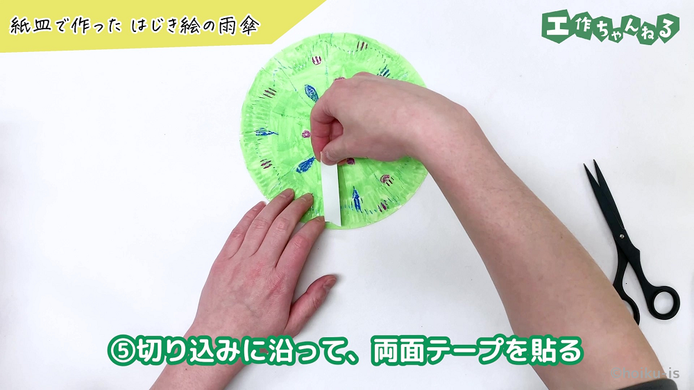 紙皿に両面テープを貼り付けている手元
