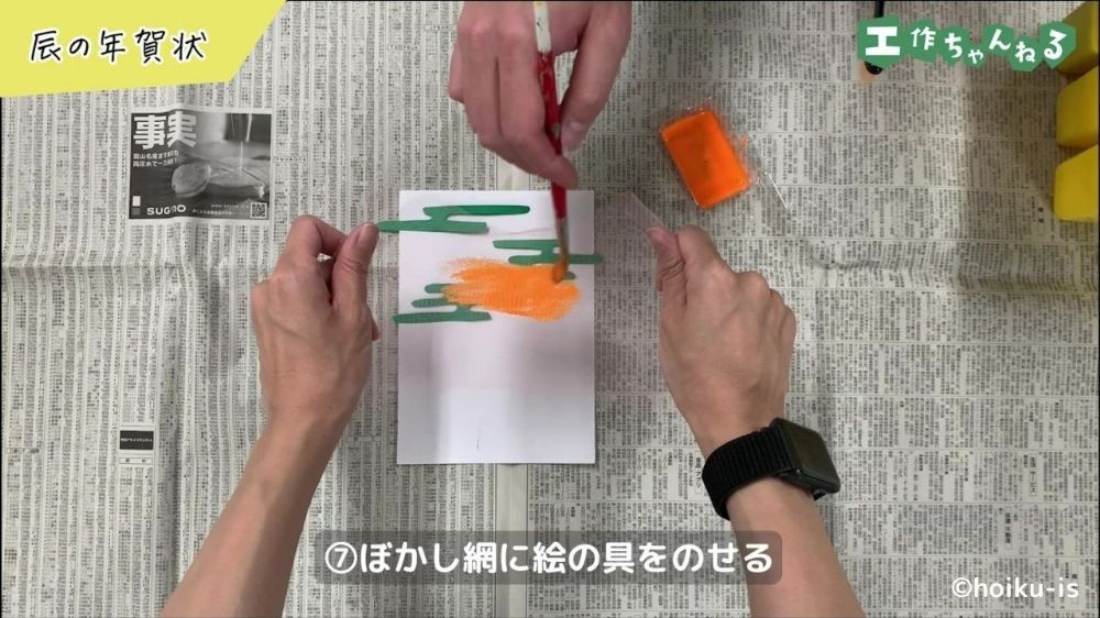 網の上に絵の具をのせている手元