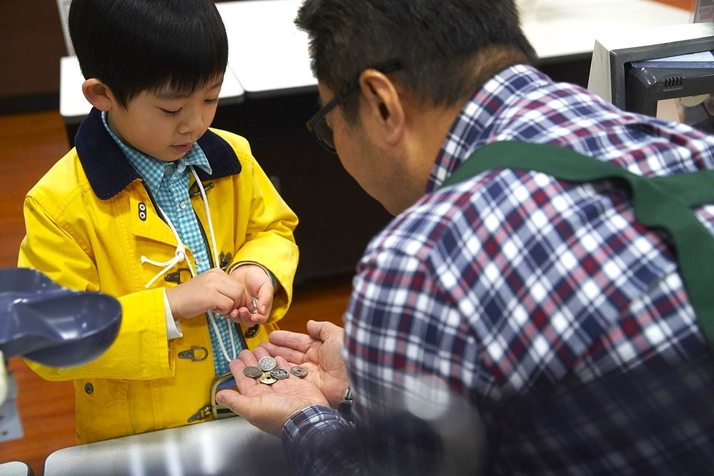 買い物で小銭を払う子ども