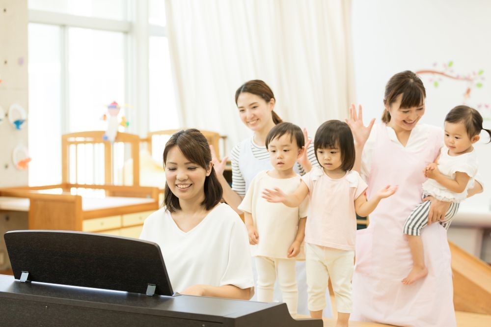 手遊びをする保育士と子どもたち