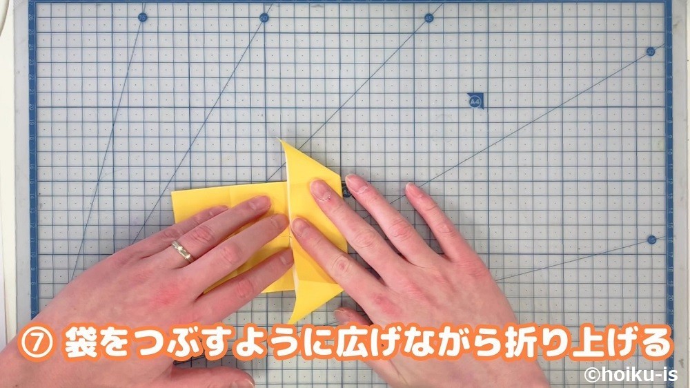 袋をつぶすように広げながら折り上げる
