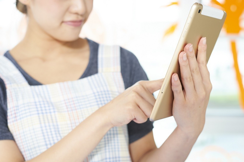 タブレットを操作する保育士