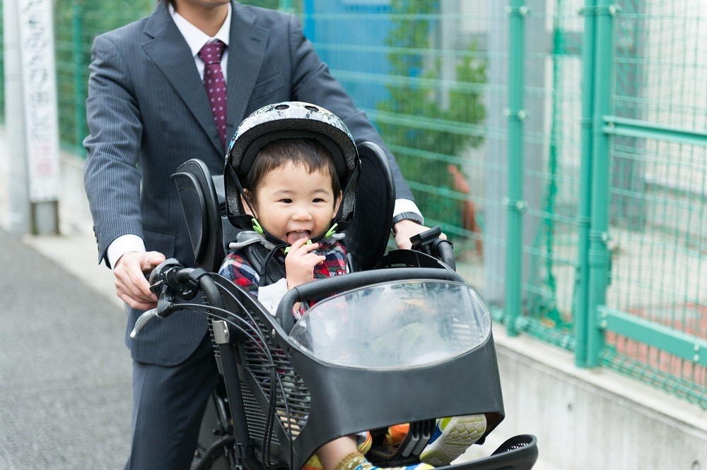 自転車で子どもを送り迎えする父親