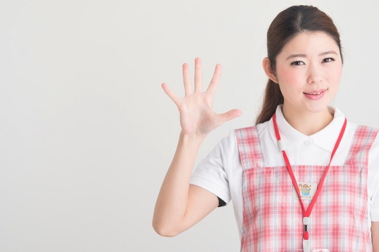 手を広げて手のひらを見せている保育士