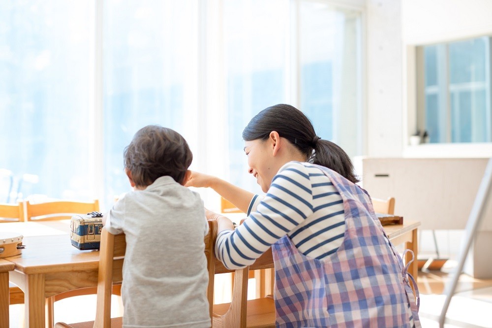 園児に話しかけている保育士