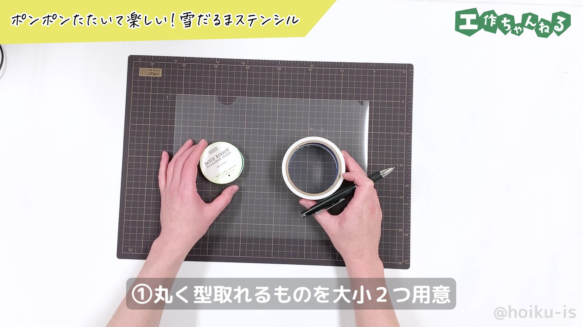 クリアファイルの上に丸いものを置いている手