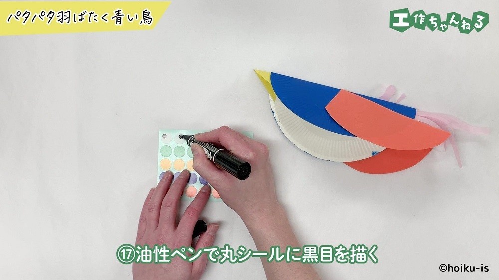 油性ペンでシールに丸を描き込んでいる手元