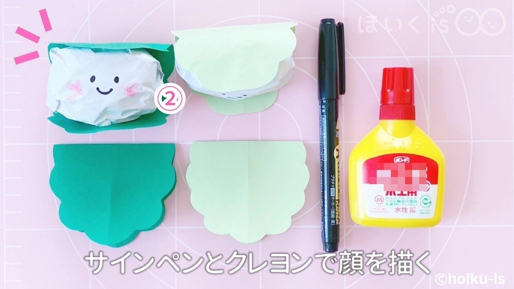 サインペンとクレヨンで顔を描いているところ