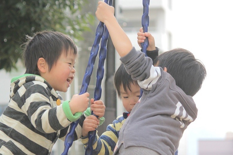 ブランコに乗る3人の男の子