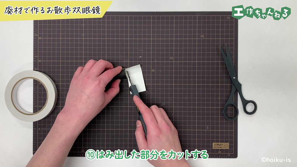 はみ出している部分をカッターでカットしている手元