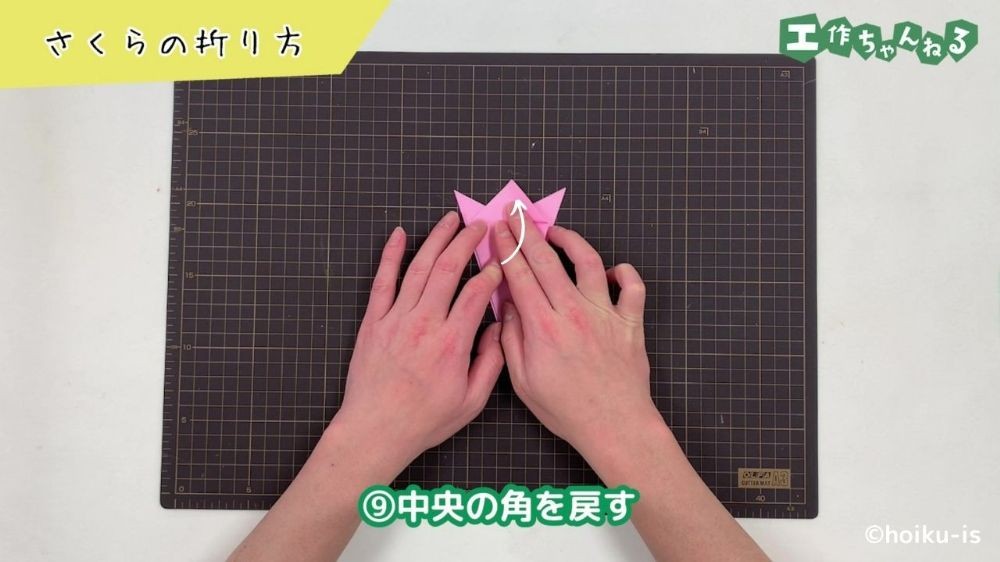 折り紙の折っていた角を開いて戻している手元