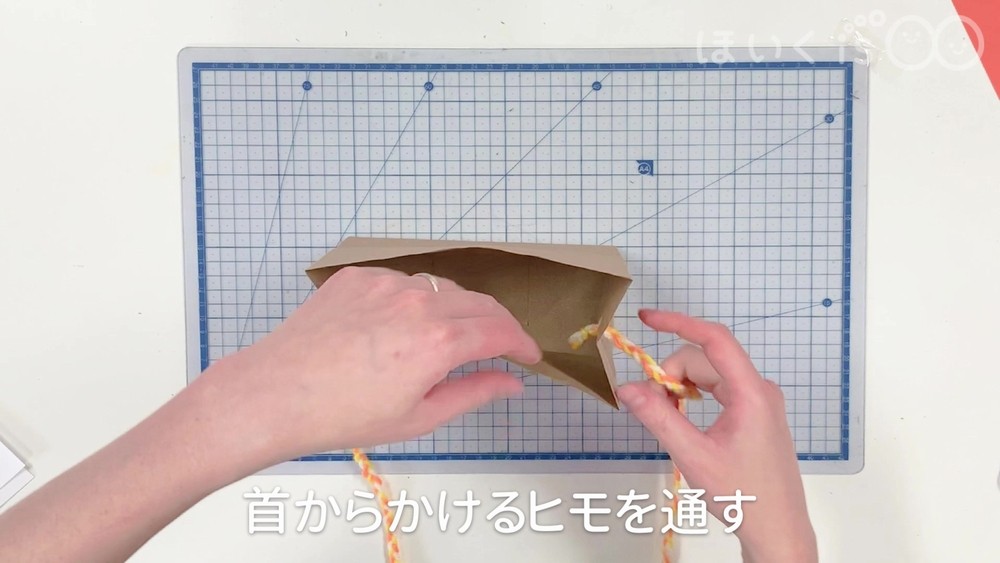 首からかけるヒモを通す