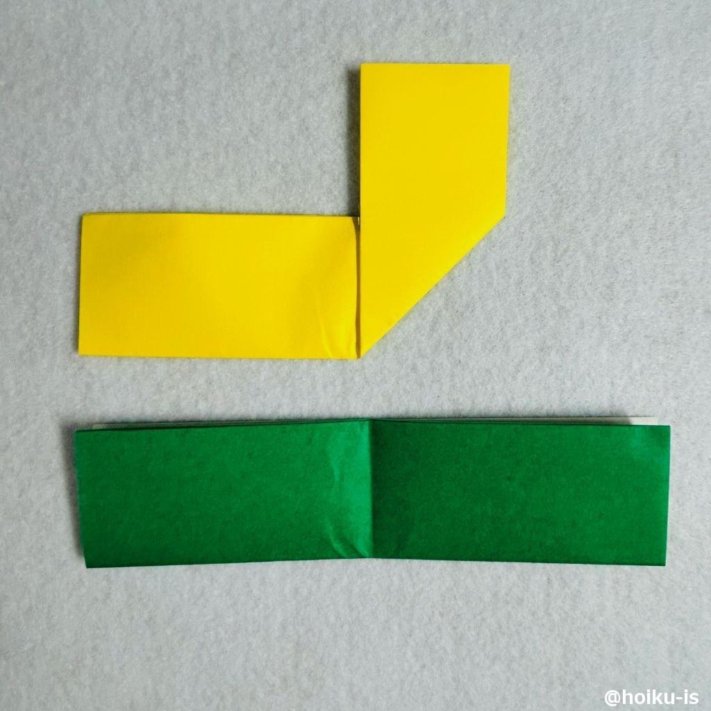 ⑥黄色の折り紙の右半分を、中央の折り筋に合わせて上向きに折る。