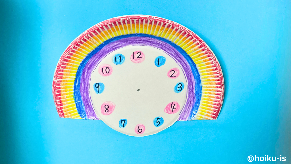 紙皿の時計の中心にキリで穴をあける