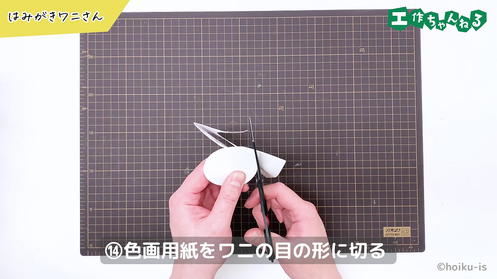 画用紙を丸く切っている手元