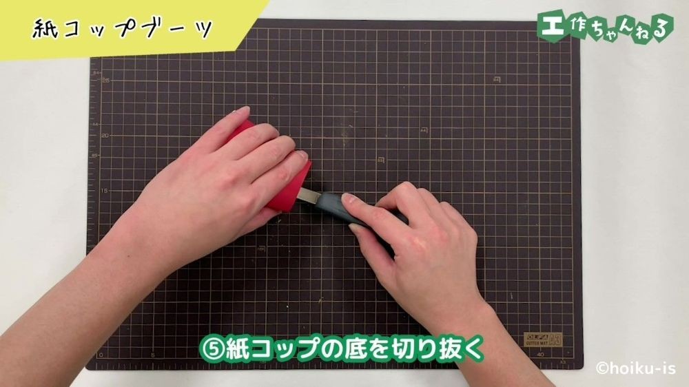 紙コップの底をカッターで切り抜いている手元