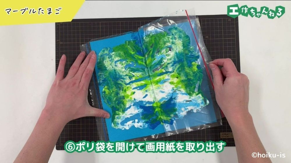 ポリ袋から画用紙を取り出している手元