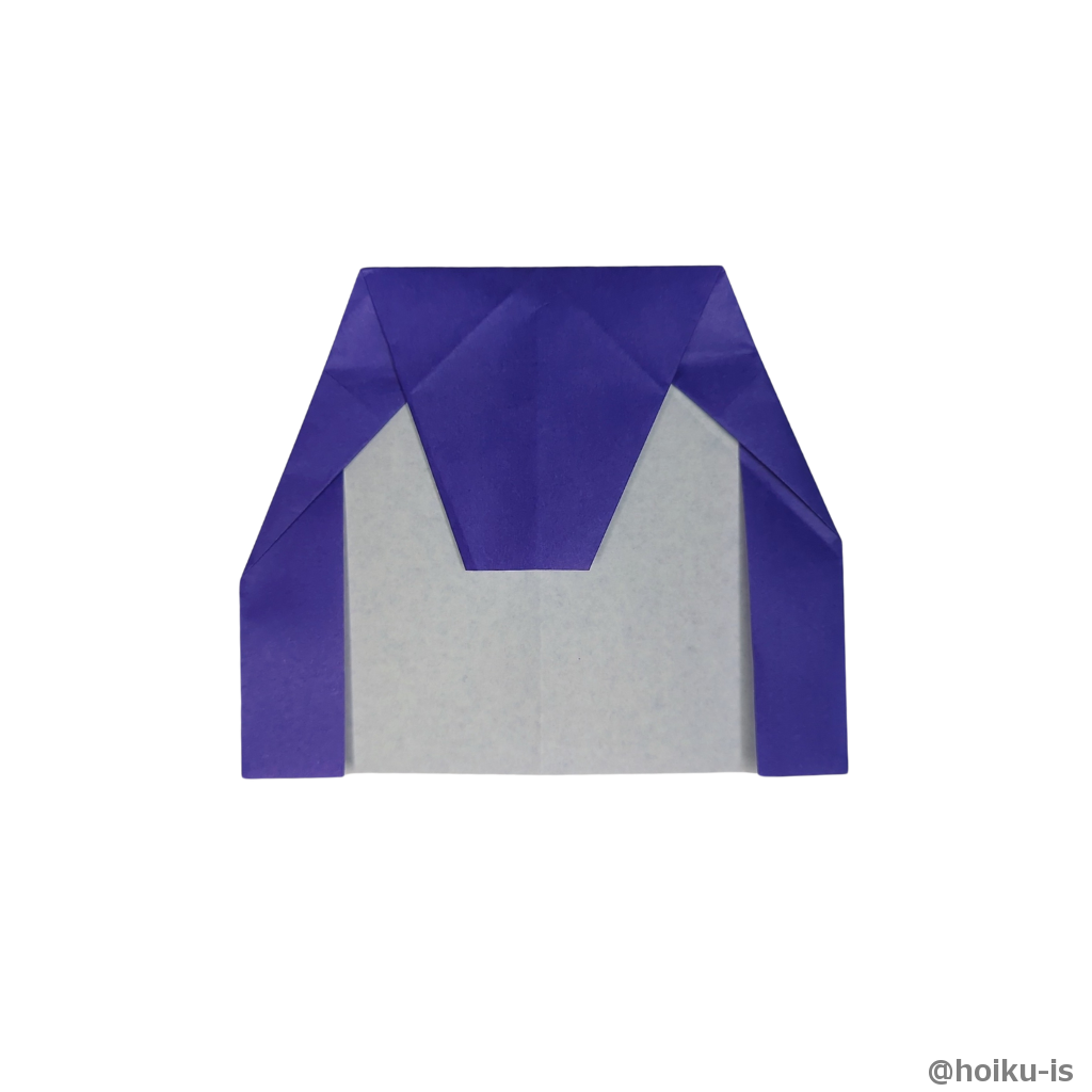 左右の折り目が重なった点に合わせて上の部分を手前に折る