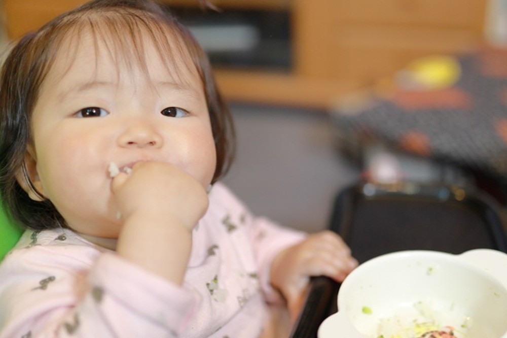 手づかみ食べをしている女の子