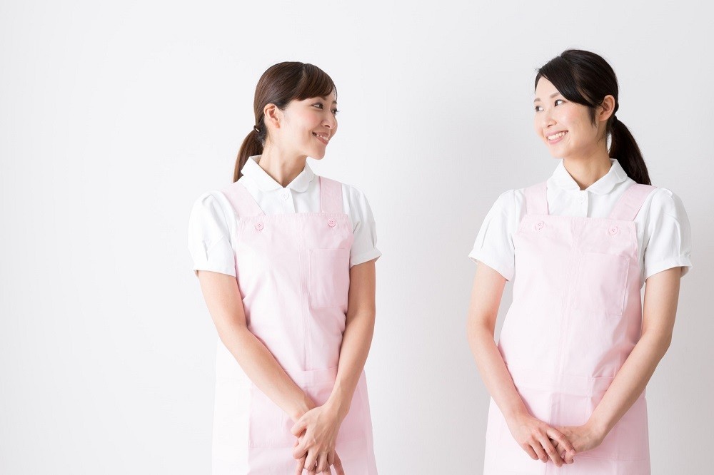 笑いながら顔を見合わせている保育士たち