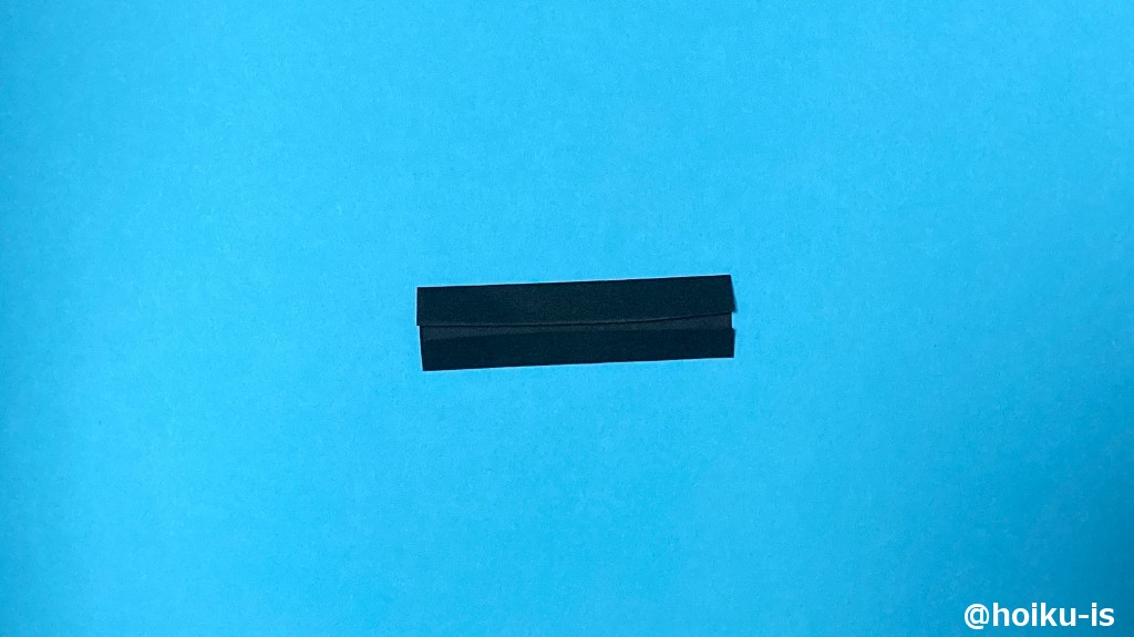 15、14で余った折り紙を半分に切り、縦長になるように内側に向かって折る。