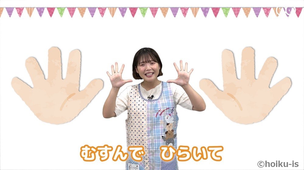 保育士が手遊び歌「むすんでひらいて」を実演しているところ