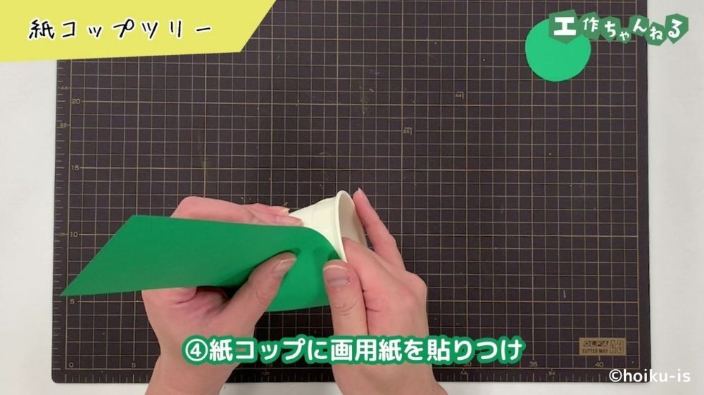 紙コップに画用紙を貼り付けている手元