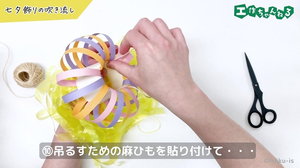 ぼんぼりに麻ひもを貼り付けている手元