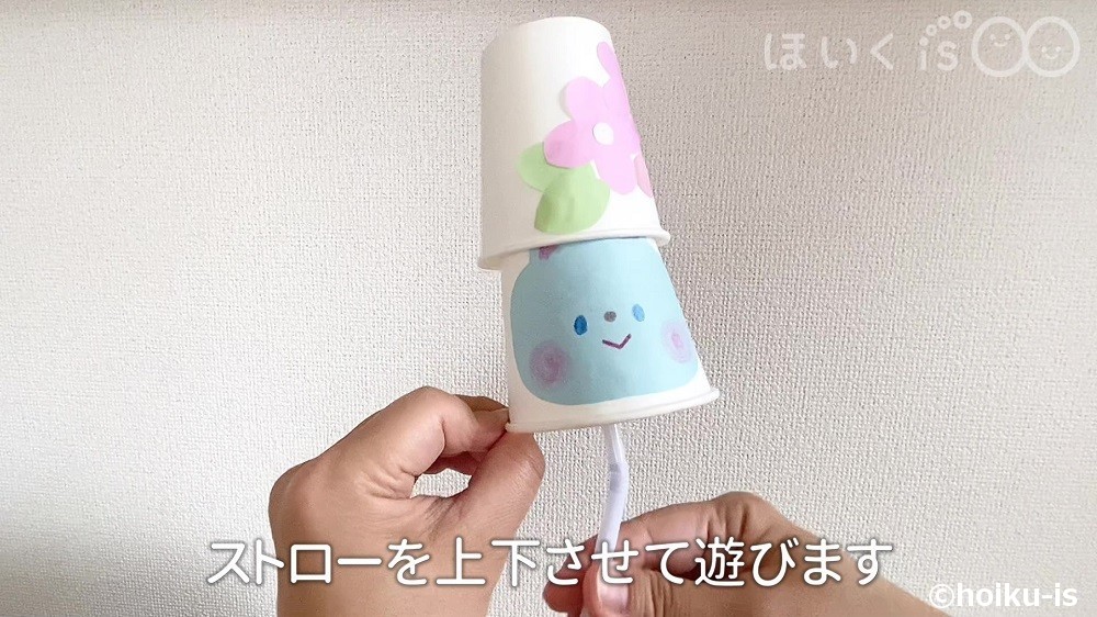 ストローを上下させて遊んでいる場面