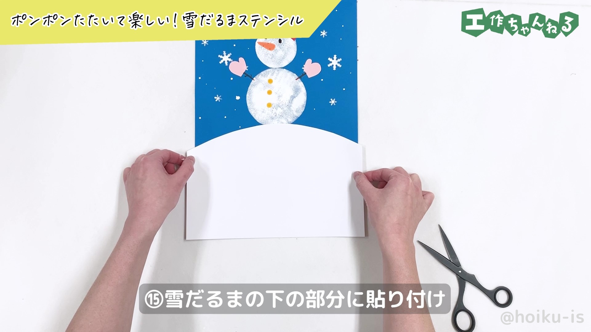 青い画用紙に白い画用紙を貼り付けている様子