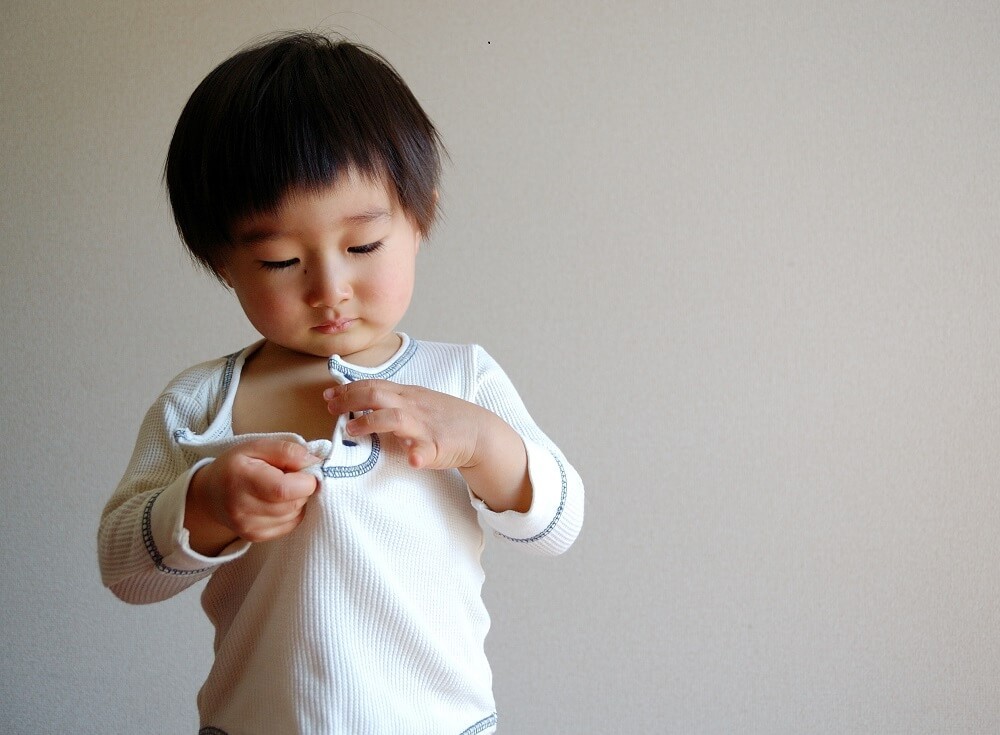 ボタンを留める子ども