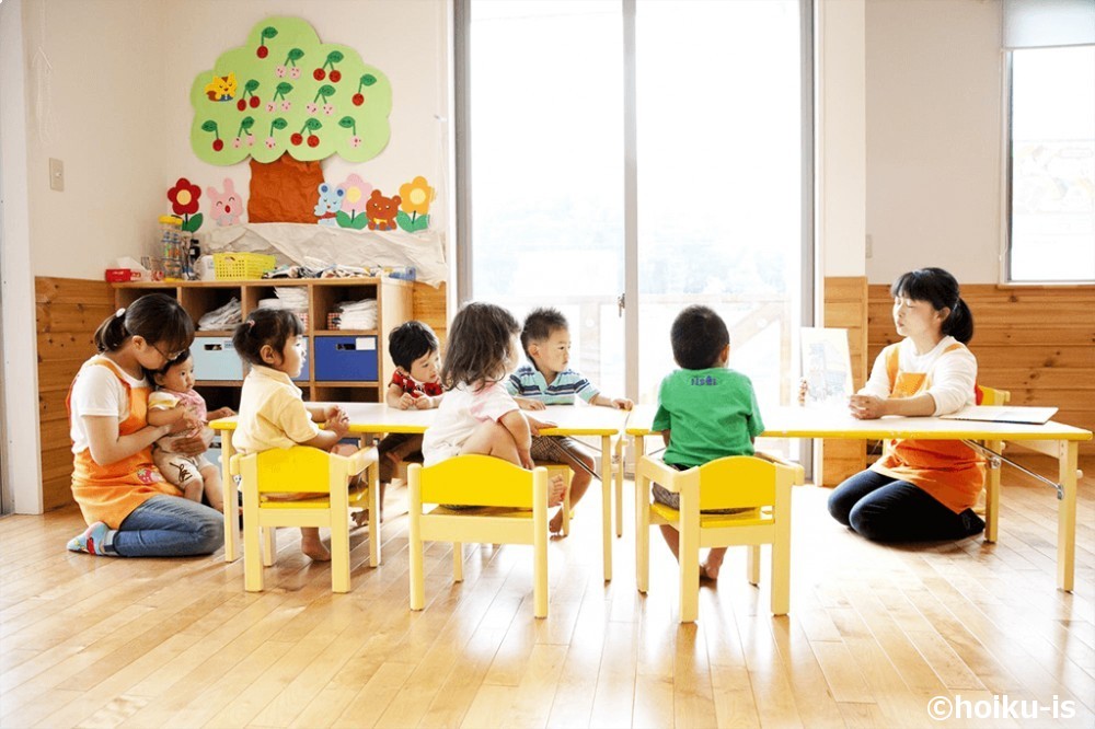 保育園内で子どもたちに読み聞かせをする保育士