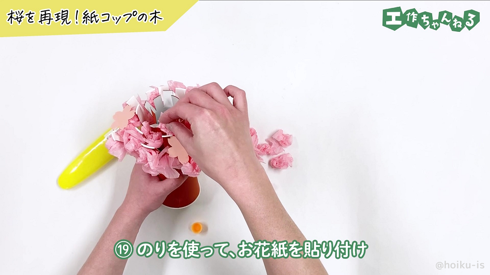 桜の木にお花紙を貼り付けている様子