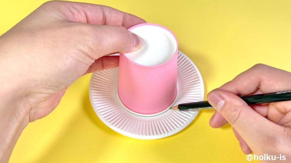 紙コップの飲み口を下にして紙皿に置き、形どるように鉛筆で丸い線を描く