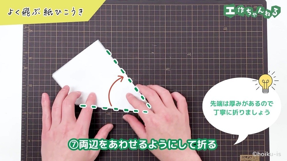 両辺をあわせるようにして折っている手元