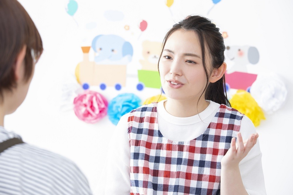 保護者に説明している保育士