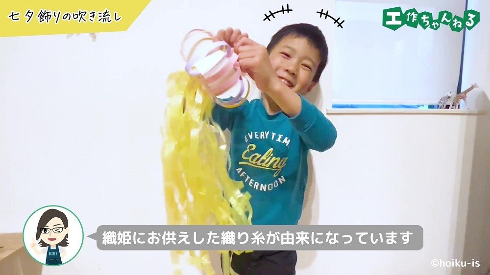 笑顔で七夕の吹き流し飾りを持つ子ども