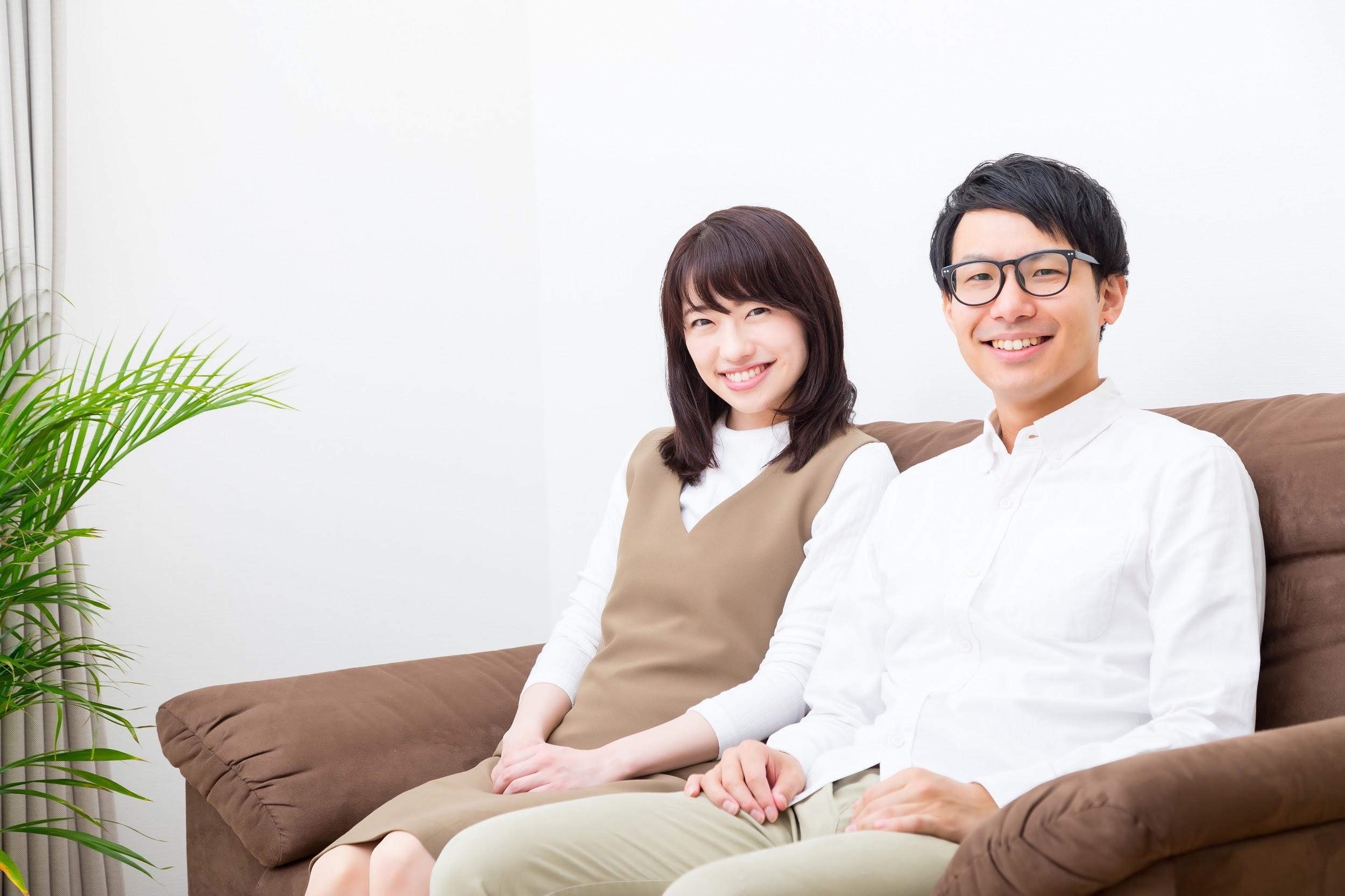 笑顔でソファーに座る男女二人