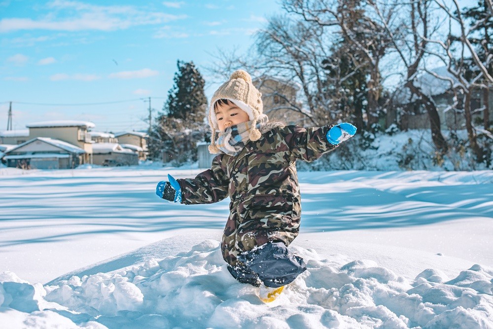 雪の上で遊んでいる男の子