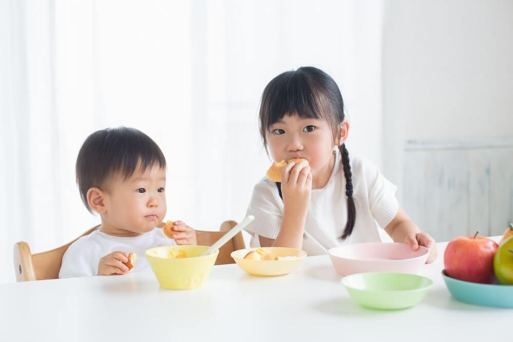 パンを食べる女の子と赤ちゃん