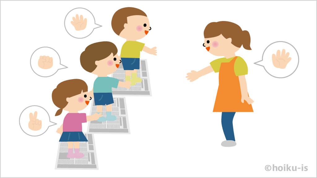 新聞紙に乗ってじゃんけんをする子どもたちと先生