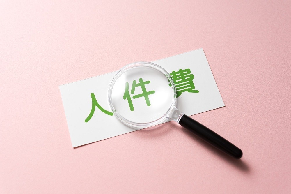 「人件費」と書かれたカードと虫眼鏡