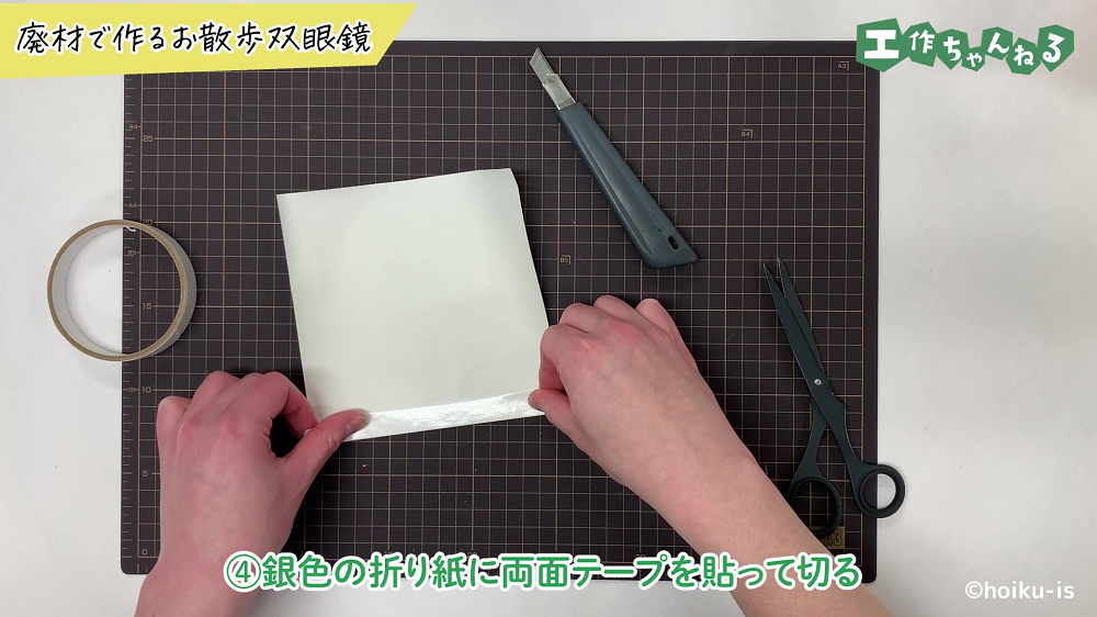 折り紙に両面テープを貼り付けている手元