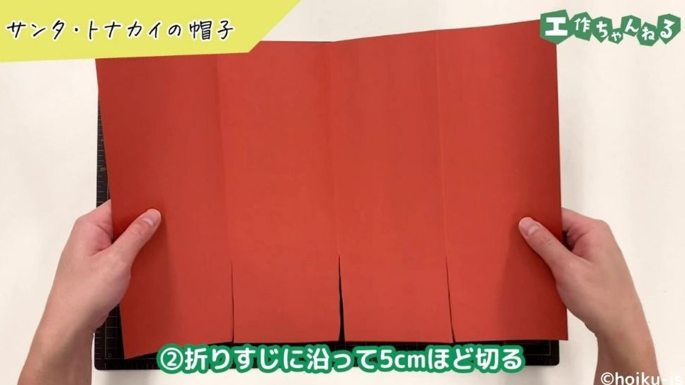 切り込みの入った画用紙を広げている手元