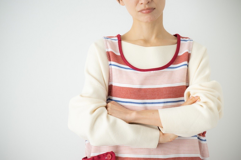 腕を組んで悩んでいる保育士