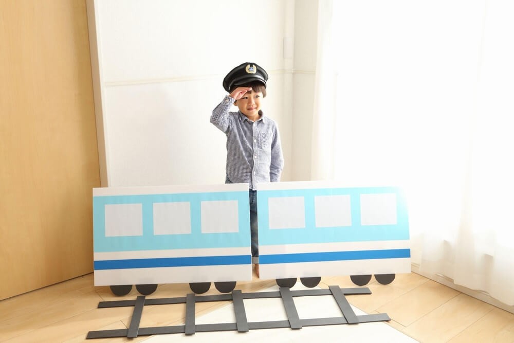電車の駅員ごっこをする男の子